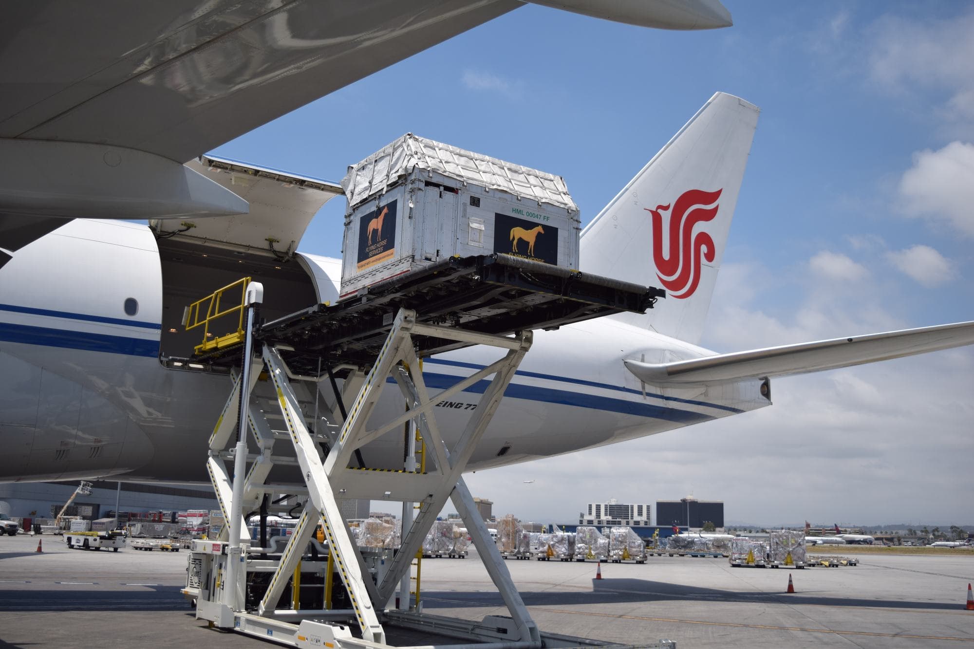 A Flying Horse Services air stall raised on a high loader to the main deck of an Air China freighter